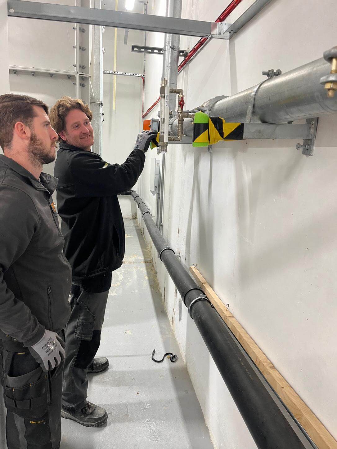 Two Trilex engineers inspecting fire system pipework installation on site